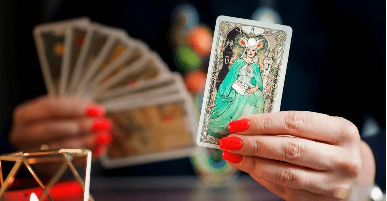 Eine Person legt Tarot-Karten auf einem Tisch aus.